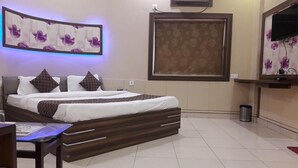 Una habitación de hotel moderna con una cama grande, un televisor de pantalla plana montado en la pared y un panel decorativo.