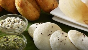Diversa selección de bocadillos indios, incluyendo frituras, pan blanco y chutneys.