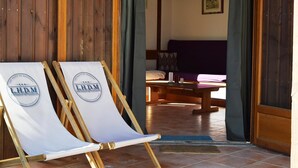 Une pièce en bois comprenant un lit, une table et deux fauteuils, chacun portant un logo.