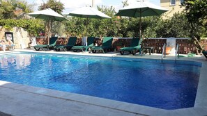 A swimming pool with green lounge chairs and umbrellas. - Kilim Hotel (Ortaca)