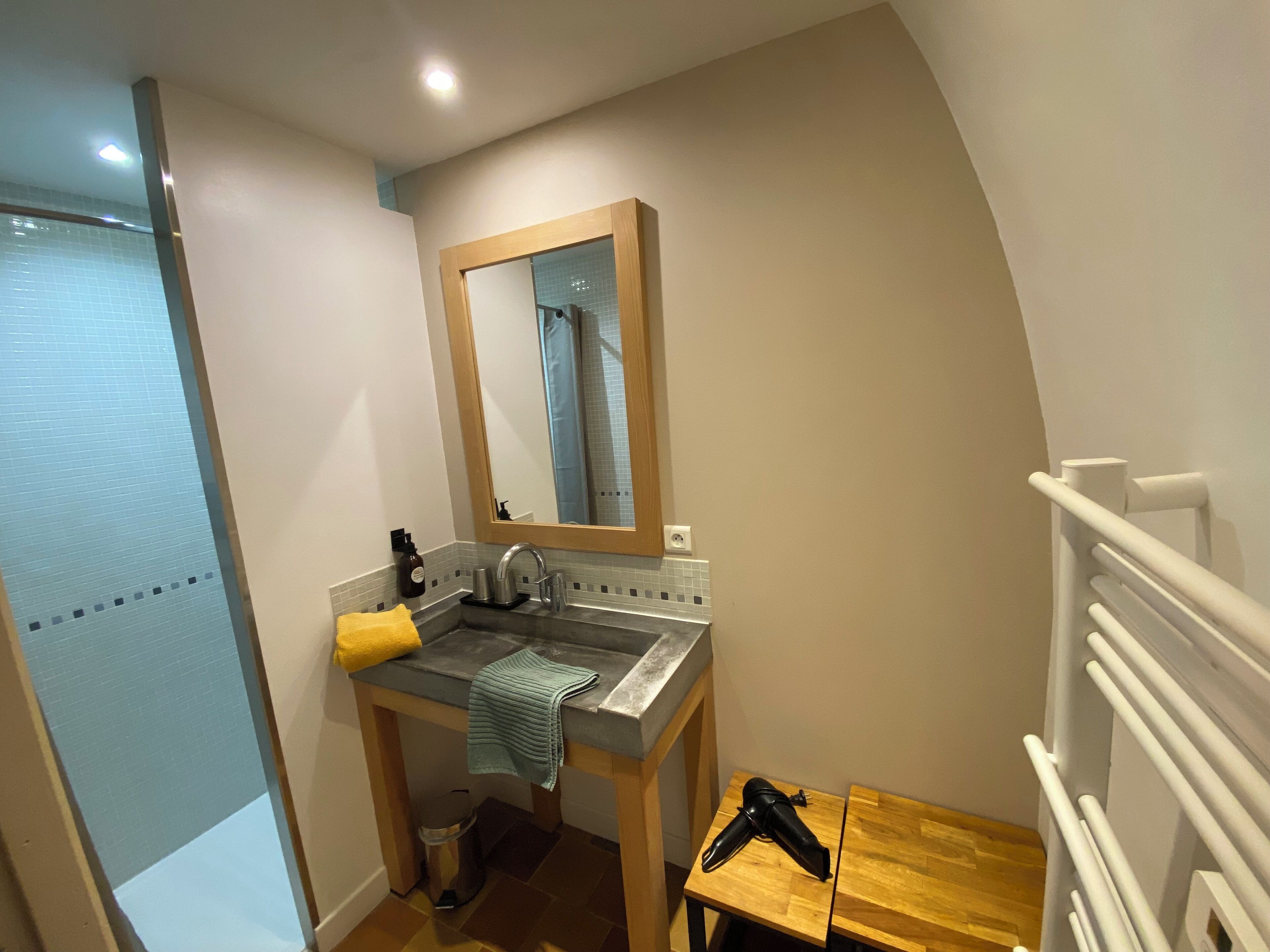 A small bathroom with a sink, mirror, and towel rack.