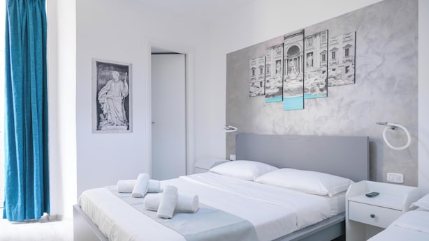 Ein modernes Hotelzimmer mit einem großen Bett, einem Nachttisch und einem Wandbild.