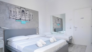 Ein modernes Hotelzimmer mit einem großen Bett, einem Nachttisch, einem Spiegel und Kunstwerken an den Wänden.
