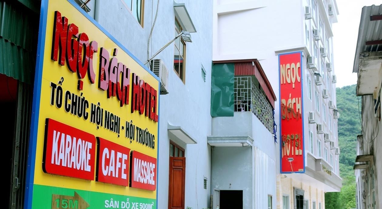 Un hotel con un cartel que anuncia karaoke, café y servicios de masaje.