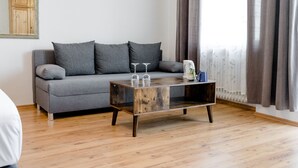A modern living room with a grey sofa, a wooden coffee table, and a radiator. - Landhaus vor Burg Eltz (Wierschem)