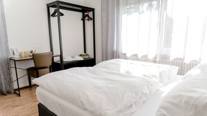 A hotel room with a large bed, a desk with a chair, a wardrobe, and a window with curtains. - Landhaus vor Burg Eltz (Wierschem)