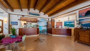 A spacious lobby with wooden beams, a bar area, and artwork on the walls.