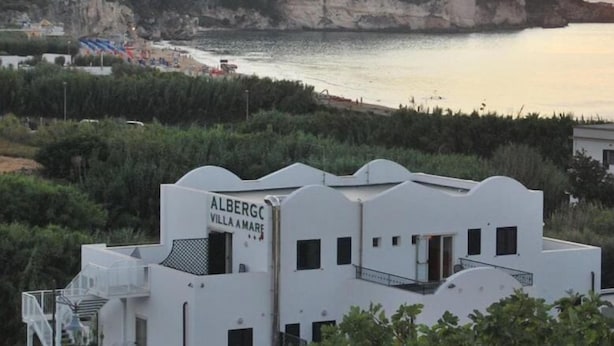 A coastal building named 'Albergc Villa Amare' with a view of the sea and cliffs.