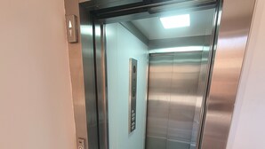 An elevator with a metallic interior, a control panel with buttons, and a light fixture on the ceiling. - Guest House Brezza Marina (Fiumicino)