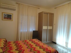 Ein Hotelzimmer mit einem Bett, einem Kleiderschrank und einem Fenster mit Vorhängen.