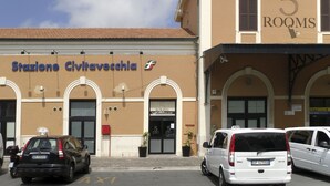 A building with a sign indicating "5 rooms" and "Stazione Civitavecchia" with a logo. - 5 Rooms (Civitavecchia)