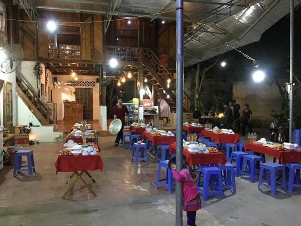 An indoor dining area with tables set for a meal, surrounded by blue stools.