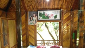 A wooden room with a bed, a framed photo, and a picture of flowers.