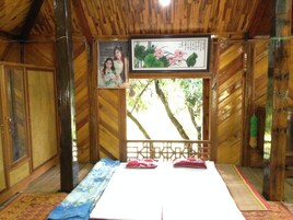 Una habitación de madera con una cama, un cuadro enmarcado y una imagen de flores.