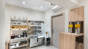 A modern kitchen with stainless steel appliances, a coffee machine, and a glass display case. - Santorini Main Square (Santorini)