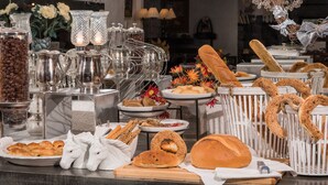 A buffet with various breads, pastries, and a coffee station. - Leandros Hotel (Aristotelis)