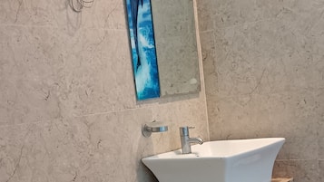 Un baño con inodoro blanco, lavabo y espejo en la pared.