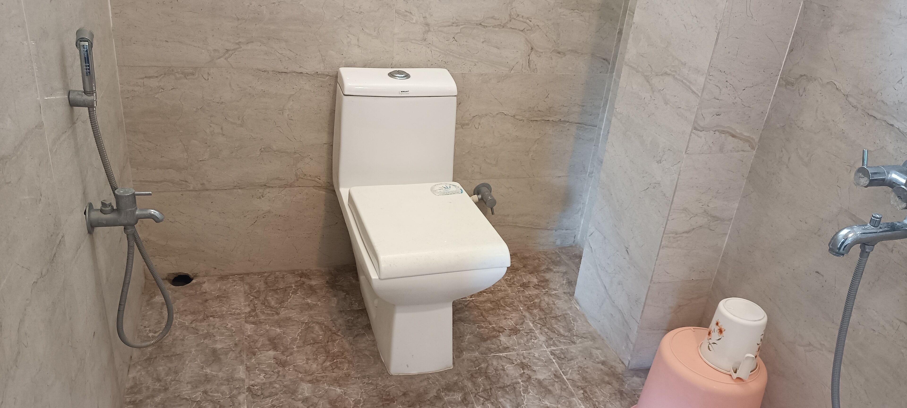 A bathroom with a toilet, a shower, and a bidet.
