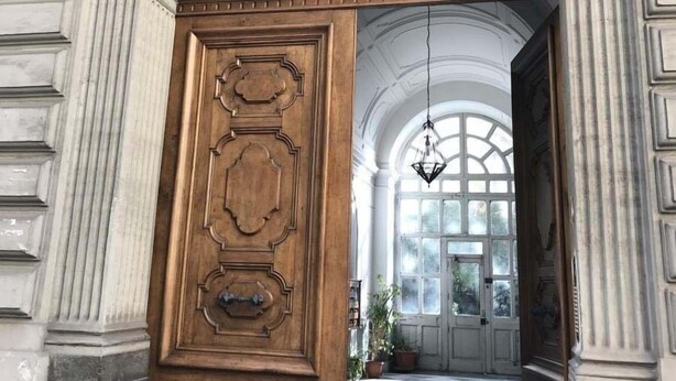 Un arcoado con intrincados grabados y una puerta de madera.