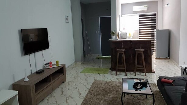 A modern living room with a flat-screen TV, wooden entertainment unit, and a coffee table.