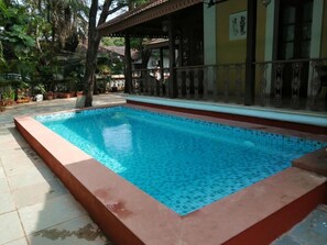 Relax by the pool surrounded by lush greenery and a beautifully designed seating area.