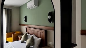 Una habitación de hotel con una cama, un escritorio pequeño, una silla y una ventana.