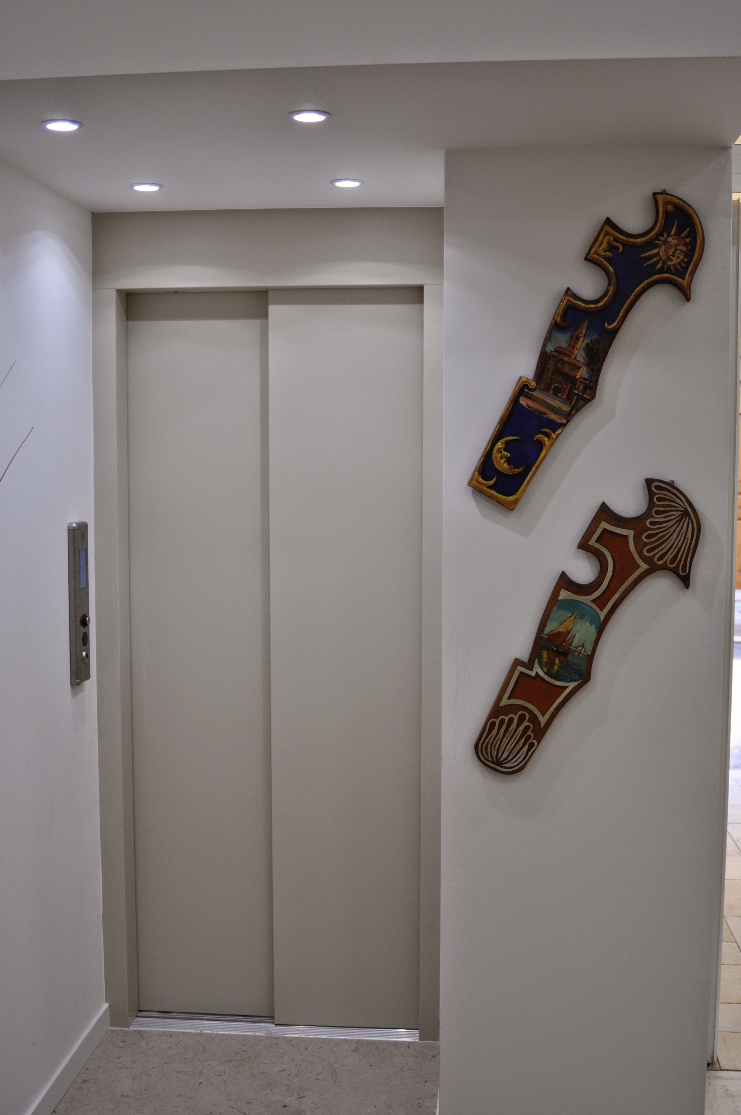 A modern elevator with a plain wall and a door.