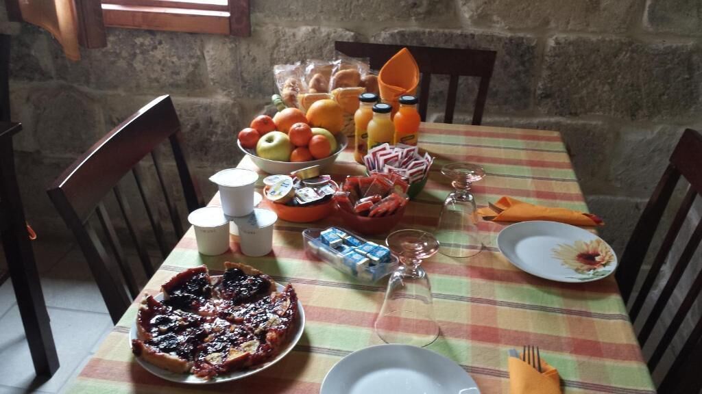 Ein Esstisch reichhaltig gedeckt mit verschiedenen Speisen, darunter ein Kuchen, Früchte und Gewürzen.