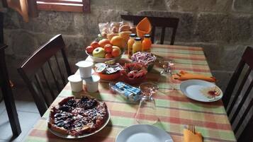 Ein Esstisch reichhaltig gedeckt mit verschiedenen Speisen, darunter ein Kuchen, Früchte und Gewürzen.