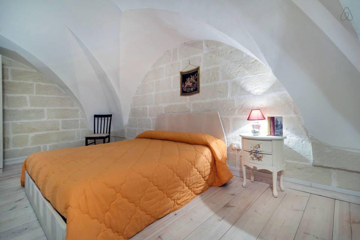 Ein Schlafzimmer mit einem Bett, einem Nachttisch und einem Stuhl.
