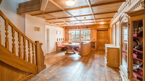Un intérieur en bois comprenant un escalier, un coin repas et une cuisine.