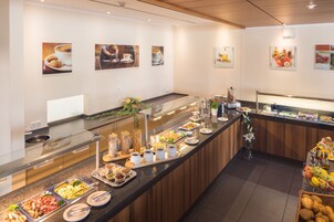 Disposição de buffet com diversos alimentos e um espaço para café.
