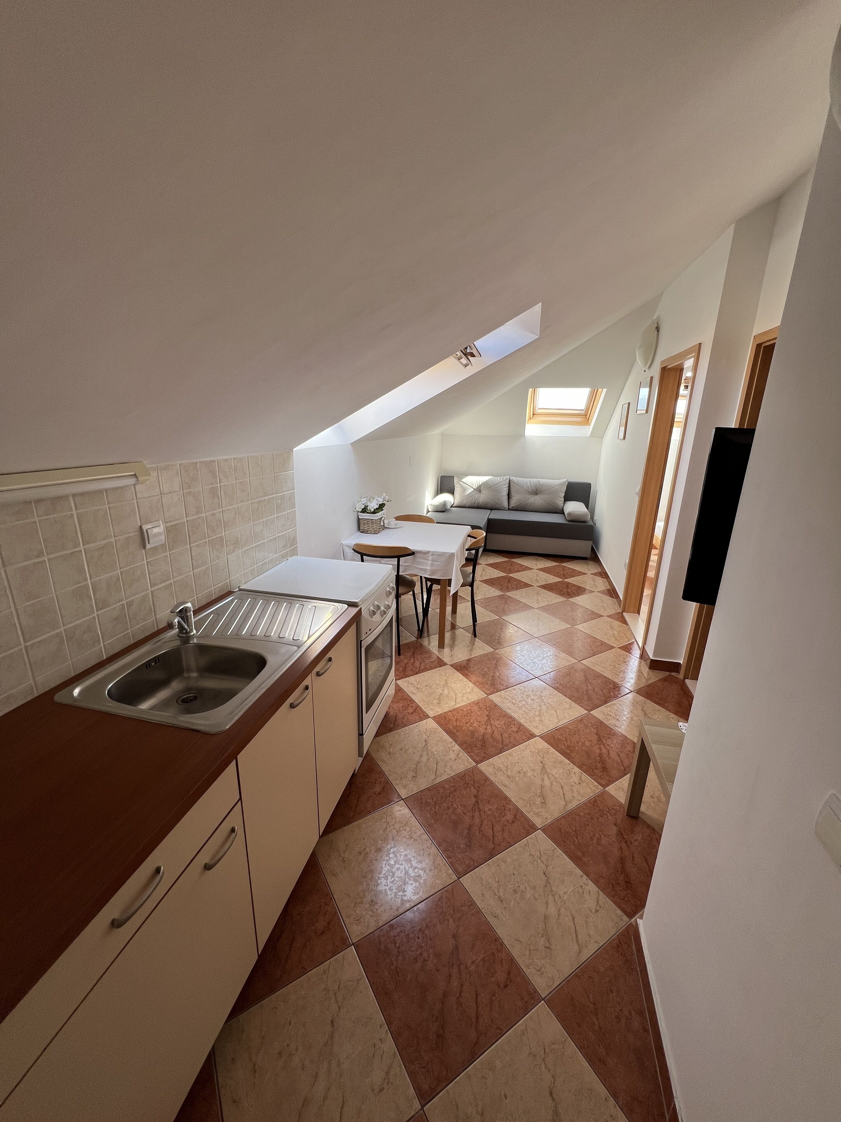 Una cuina petita amb rentapesos, fogó i zona de dinar.