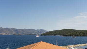 A harbor with boats, a dock, and a mountainous backdrop.