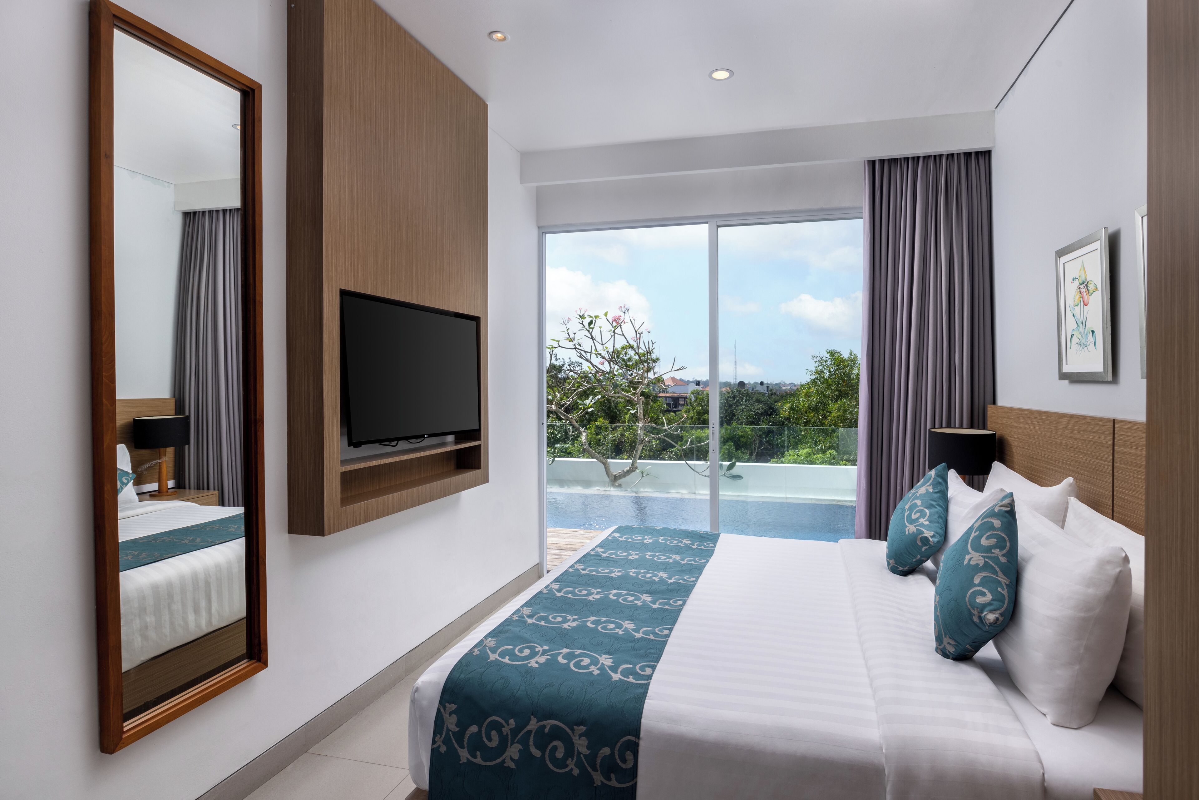 Una habitación de hotel moderna con una cama grande, televisión, vistas al exterior y un balcón.