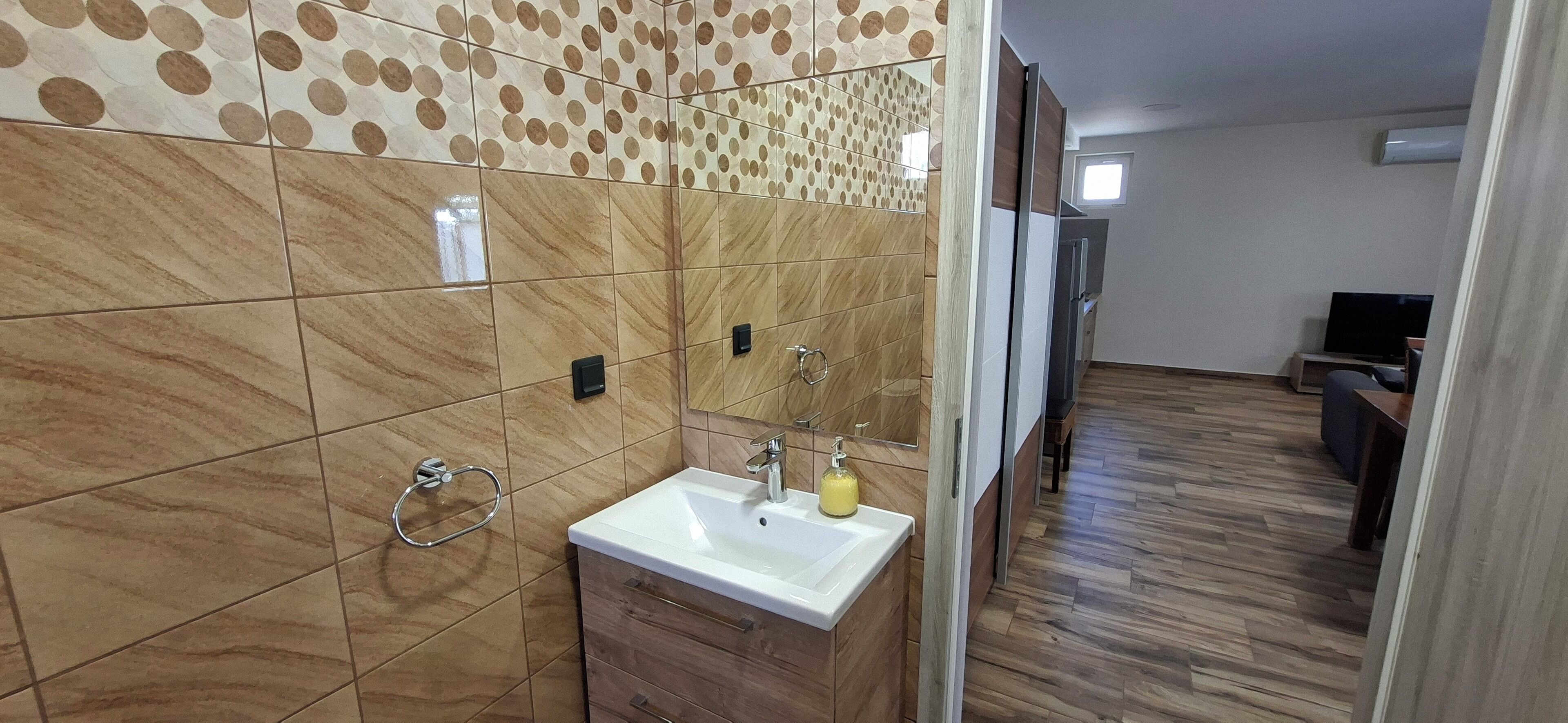 A bathroom with a sink, mirror, and towel rack.