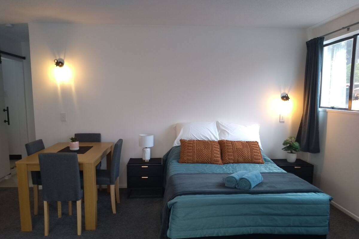 Une chambre à coucher comprenant un lit, un bureau, des chaises et des tables de chevet.