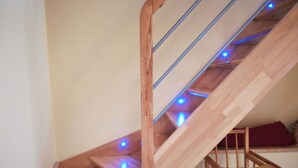 A wooden spiral staircase with blue LED lighting. - New Kertzfeld cottage, luxury performance in Alsace countryside. (Kertzfeld)