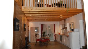 A spacious kitchen with a dining area, wooden ceiling, and a view to the upper level. - New Kertzfeld cottage, luxury performance in Alsace countryside. (Kertzfeld)