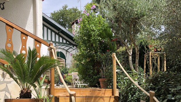 A wooden staircase with a rope handrail leading to a house with a balcony. - Town house ideal for a couple with children (Arcachon)
