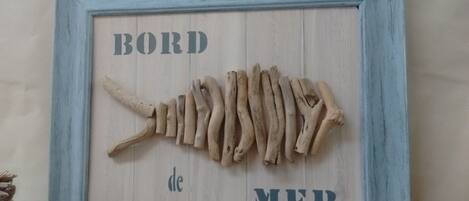 Ein gerahmtes Holzmodell eines Fischskeletts mit der Aufschrift 'BORD de MER'.