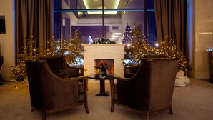 Una habitación con dos sillones, una mesita y una chimenea decorada para Navidad.