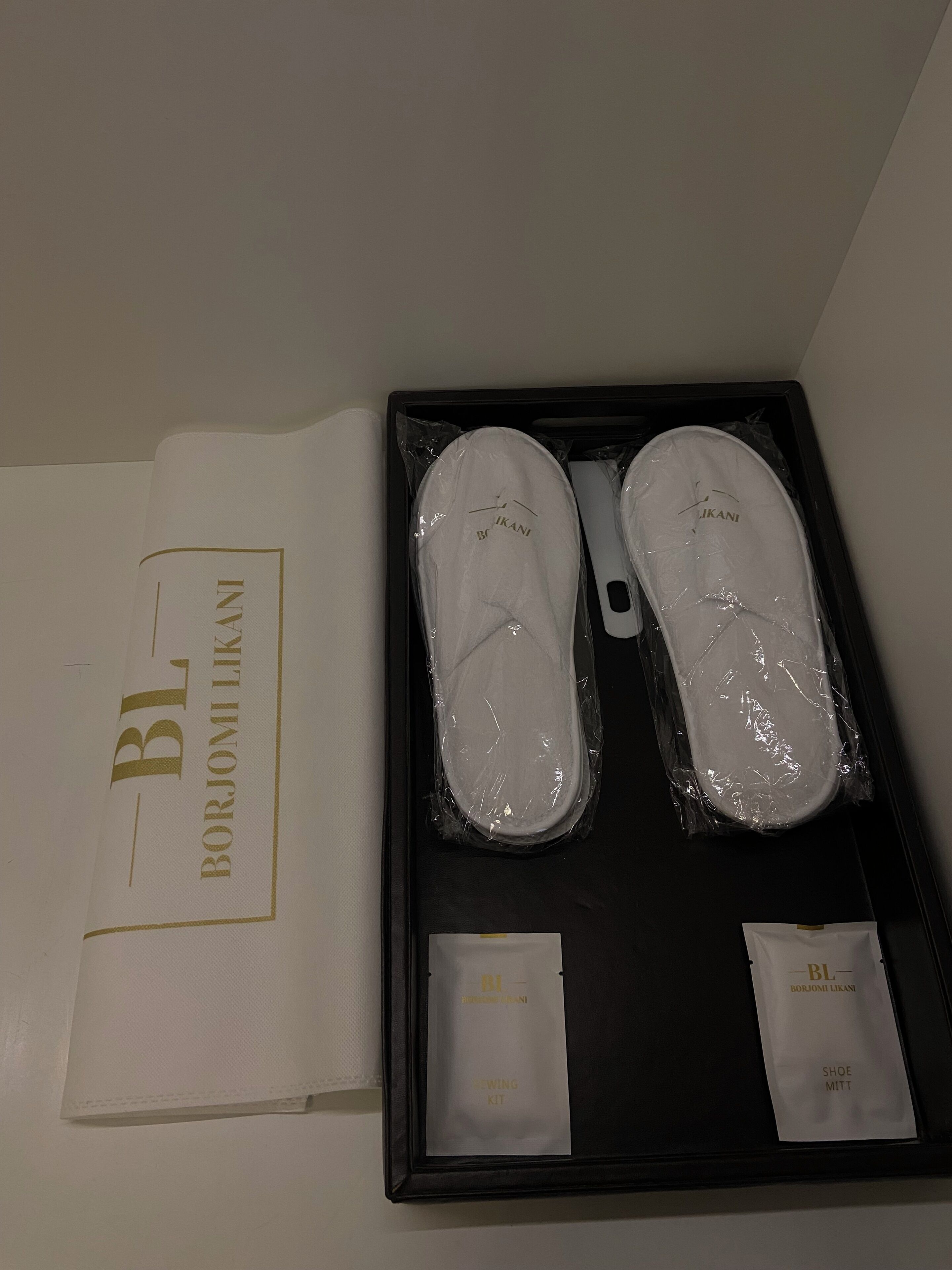 A shoe care kit with two pairs of shoes and a sewing kit.
