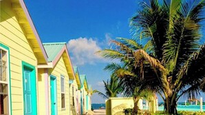 A row of colorful beach cottages with a clear view of the ocean.