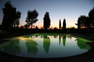 Una piscina al aire libre de temporada, sombrillas