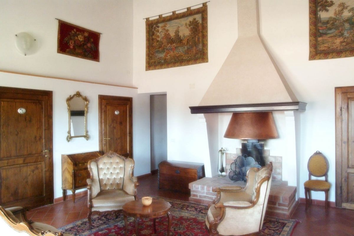 Ein traditionelles Wohnzimmer mit Holzmöbeln, einem Kamin und Kunstwerken an den Wänden.