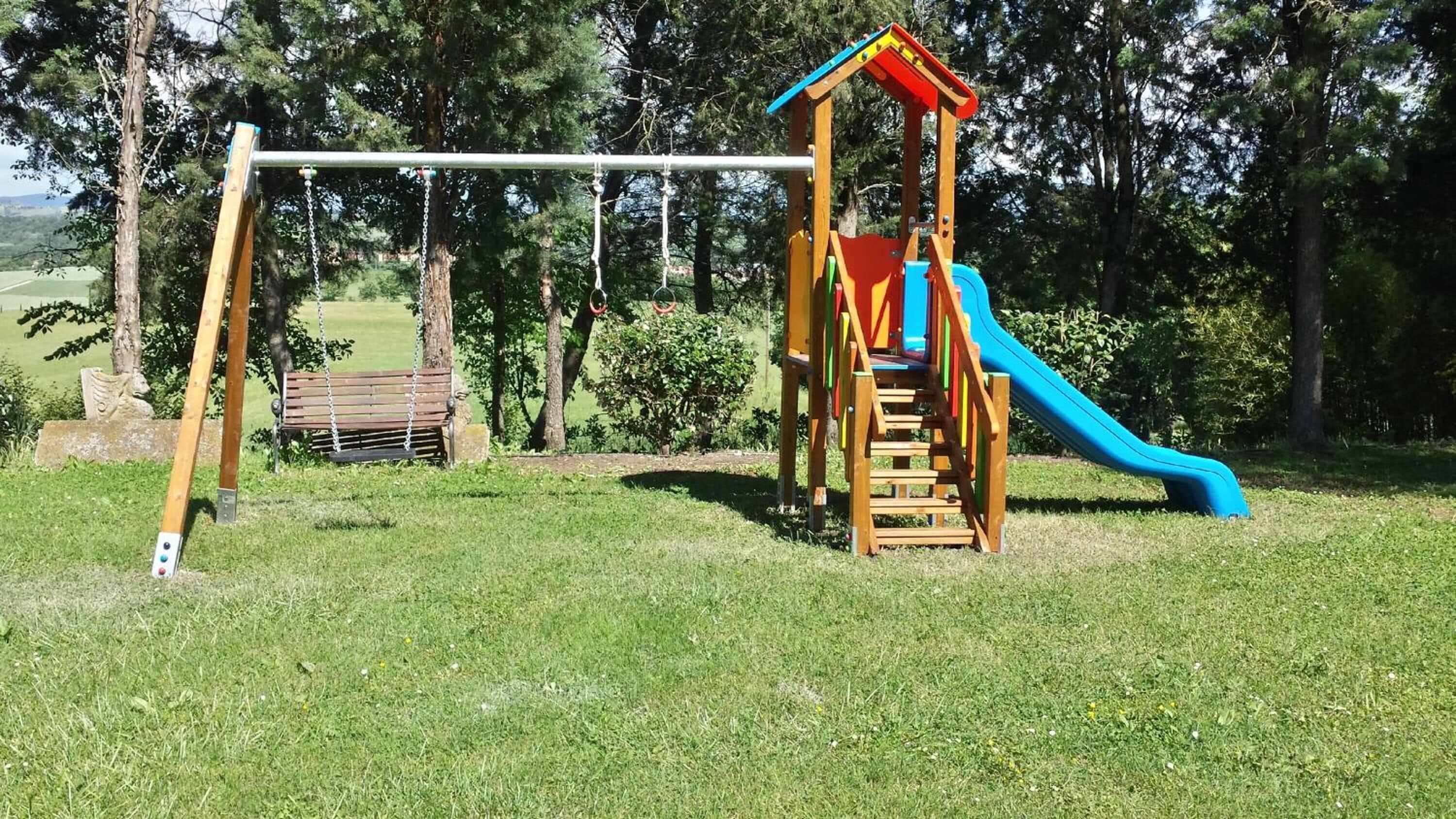 A playground with a swing set, slide, and climbing structure.