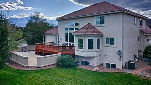 Ein zweistöckiges Haus mit rotem Ziegeldach, einer überdachten Terrasse und einer Satellitenschüssel.