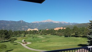 Ein Golfplatz mit freiem Blick auf Berge im Hintergrund.