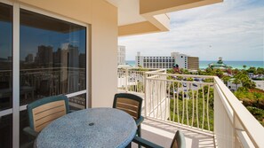 Enjoy a coastal view from this balcony with a table and chairs.